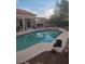Outdoor living area features a refreshing pool, covered patio, and desert landscaping at 7894 W Patrick Ln, Las Vegas, NV 89113
