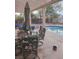Backyard patio area with seating, a pool, and a shade structure for relaxing outdoors at 7894 W Patrick Ln, Las Vegas, NV 89113