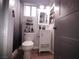 This bathroom features a single vanity, a toilet, wood-look flooring, and shelving at 8072 Cimarron Ridge Dr # 201, Las Vegas, NV 89128