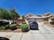 Inviting two-story townhome featuring a tile roof, well-manicured landscaping, and attached two-car garage at 8072 Cimarron Ridge Dr # 201, Las Vegas, NV 89128