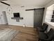 Living room featuring modern décor, wood laminate flooring and barn door at 8072 Cimarron Ridge Dr # 201, Las Vegas, NV 89128