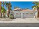 Beautiful single-story home showcasing a three-car garage, complemented by lush palm trees and attractive landscaping at 8124 Bay Harbor Dr, Las Vegas, NV 89128