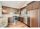 Modern kitchen with granite countertops, wood cabinets, and stainless-steel appliances on gleaming wood floors at 8124 Bay Harbor Dr, Las Vegas, NV 89128