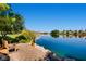 Lake view featuring park benches, mature landscaping, and homes in the distance at 8124 Bay Harbor Dr, Las Vegas, NV 89128