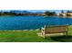 Beautiful lake view featuring a wooden bench on green grass with mountains in the background at 8124 Bay Harbor Dr, Las Vegas, NV 89128