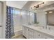 Bathroom featuring a double vanity, shower-tub combo, and a light fixture above the mirror at 832 Seco Verde Ave, Henderson, NV 89015