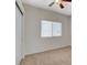 Well-lit bedroom showcasing neutral carpet, closet with sliding doors and a large window at 832 Seco Verde Ave, Henderson, NV 89015