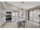 Bright kitchen featuring stainless steel appliances, island with breakfast bar, tile flooring, and sliding doors to backyard at 832 Seco Verde Ave, Henderson, NV 89015