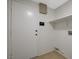 Clean laundry room with white door, open shelf, and tile flooring for easy maintenance at 832 Seco Verde Ave, Henderson, NV 89015