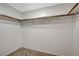 Empty walk-in closet with carpeted floor, wooden rods and white shelving for optimal storage at 832 Seco Verde Ave, Henderson, NV 89015