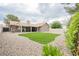 Expansive backyard with artificial turf, rock landscaping, and a covered patio at 8757 Beluga Way, Las Vegas, NV 89117