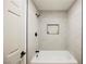 Modern bathroom features a white tub with black hardware and light tiled walls at 8757 Beluga Way, Las Vegas, NV 89117