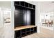Hallway featuring a dark-stained built-in mudroom storage bench with wood accents and access to living area at 8757 Beluga Way, Las Vegas, NV 89117