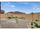 View of the backyard featuring gravel, stone pavers, desert landscaping and block fence at 8801 Trotternish Ridge Dr, Las Vegas, NV 89166