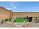 Charming backyard sitting area with artificial turf, desert landscaping, pavers, and block wall at 8801 Trotternish Ridge Dr, Las Vegas, NV 89166