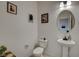Powder room with white toilet, pedestal sink, and neutral paint at 8801 Trotternish Ridge Dr, Las Vegas, NV 89166