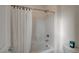 Clean white bathroom featuring a shower-tub combo and white tiling at 8801 Trotternish Ridge Dr, Las Vegas, NV 89166