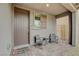Inviting front porch featuring a covered seating area, brick-paved entrance, and stylish neutral tones at 8801 Trotternish Ridge Dr, Las Vegas, NV 89166