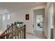 Bright hallway with wood banister and decorative plants leading to bedrooms with plush carpet at 8801 Trotternish Ridge Dr, Las Vegas, NV 89166