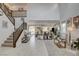 Bright, open-concept living room with high ceilings, tile floors, and abundant natural light, adjacent to staircase at 8801 Trotternish Ridge Dr, Las Vegas, NV 89166