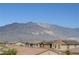 Neighborhood street showcases houses with tiled roofs and beautiful mountain backdrop, blending community and nature at 8801 Trotternish Ridge Dr, Las Vegas, NV 89166