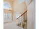 Elegant foyer featuring a grand staircase, chandelier, tile flooring, and a view into a bright, inviting living space at 9404 Low Tide Ct, Las Vegas, NV 89117