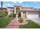 Inviting two-story home with mature landscaping and a brick walkway at 9404 Low Tide Ct, Las Vegas, NV 89117