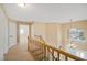 Upper landing showcases carpet, wood railing, and view of foyer with decorative window; multiple rooms nearby at 9404 Low Tide Ct, Las Vegas, NV 89117