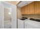 Bright laundry room with modern white washer and dryer, adjacent to another tiled room seen through an open door at 9404 Low Tide Ct, Las Vegas, NV 89117