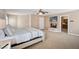 Bright bedroom with a fireplace, TV, neutral carpet, large bed and entry into bathroom with wooden cabinets at 9404 Low Tide Ct, Las Vegas, NV 89117