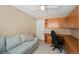 Functional office space featuring built-in shelving, a comfortable sofa, and a corner desk with an ergonomic chair at 9404 Low Tide Ct, Las Vegas, NV 89117