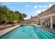 Sparkling backyard pool with clear water, surrounded by lush greenery and patio at 9404 Low Tide Ct, Las Vegas, NV 89117