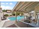 Backyard pool and covered patio with fan and comfortable outdoor seating at 9404 Low Tide Ct, Las Vegas, NV 89117