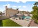 Backyard pool with spa, outdoor kitchen, dining area, and lounge chairs at 9404 Low Tide Ct, Las Vegas, NV 89117