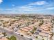 An aerial view showcases a residential neighborhood with uniform homes, clear blue skies, and a cityscape in the distance at 9541 Vast Valley Ave, Las Vegas, NV 89148
