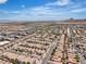 An elevated view captures a vast, orderly suburban area with uniform rooftops stretching to the horizon and distant mountains at 9541 Vast Valley Ave, Las Vegas, NV 89148