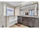 Bright bathroom featuring a double vanity with granite counters, soaking tub, and tiled floors at 9541 Vast Valley Ave, Las Vegas, NV 89148