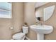 Bathroom featuring a pedestal sink, toilet and mirror at 9541 Vast Valley Ave, Las Vegas, NV 89148