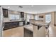 Modern kitchen features dark wood cabinets and granite countertops with island and stainless steel appliances at 9541 Vast Valley Ave, Las Vegas, NV 89148