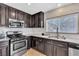 Modern kitchen featuring granite counters, stainless steel appliances, and dark wood cabinetry at 9541 Vast Valley Ave, Las Vegas, NV 89148