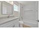 Bright bathroom features a marble tiled shower-tub, light gray vanity, and a large mirror at 9552 Gold Bank Dr, Las Vegas, NV 89134