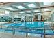Bright indoor pool area with skylights, large windows, and tiled pool with multiple swim lanes at 9552 Gold Bank Dr, Las Vegas, NV 89134