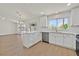 Corner view of an open kitchen/living room area, bright cabinets, and laminate floors at 9552 Gold Bank Dr, Las Vegas, NV 89134