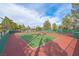 Outdoor tennis court with a well-maintained green and red playing surface under a bright blue sky at 9552 Gold Bank Dr, Las Vegas, NV 89134