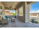 Inviting covered front porch with stylish seating, ceiling fans, and brick-paved flooring at , Henderson, NV 89011