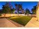 A well-lit backyard featuring artificial turf, manicured trees, and stone retaining walls for added appeal at , Las Vegas, NV 89131