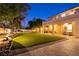 A spacious backyard featuring lush artificial turf, a covered patio, and tasteful outdoor lighting at , Las Vegas, NV 89131