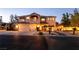 Inviting two-story home featuring a three-car garage, landscaped front yard, and warm exterior lighting at , Las Vegas, NV 89131