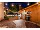 Outdoor kitchen with stainless steel grill and decorative lighting in a landscaped backyard at , Las Vegas, NV 89131