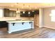 Spacious kitchen featuring a large island, dark cabinets, and wood-look flooring at 1027 Cambridge Park St, Las Vegas, NV 89148